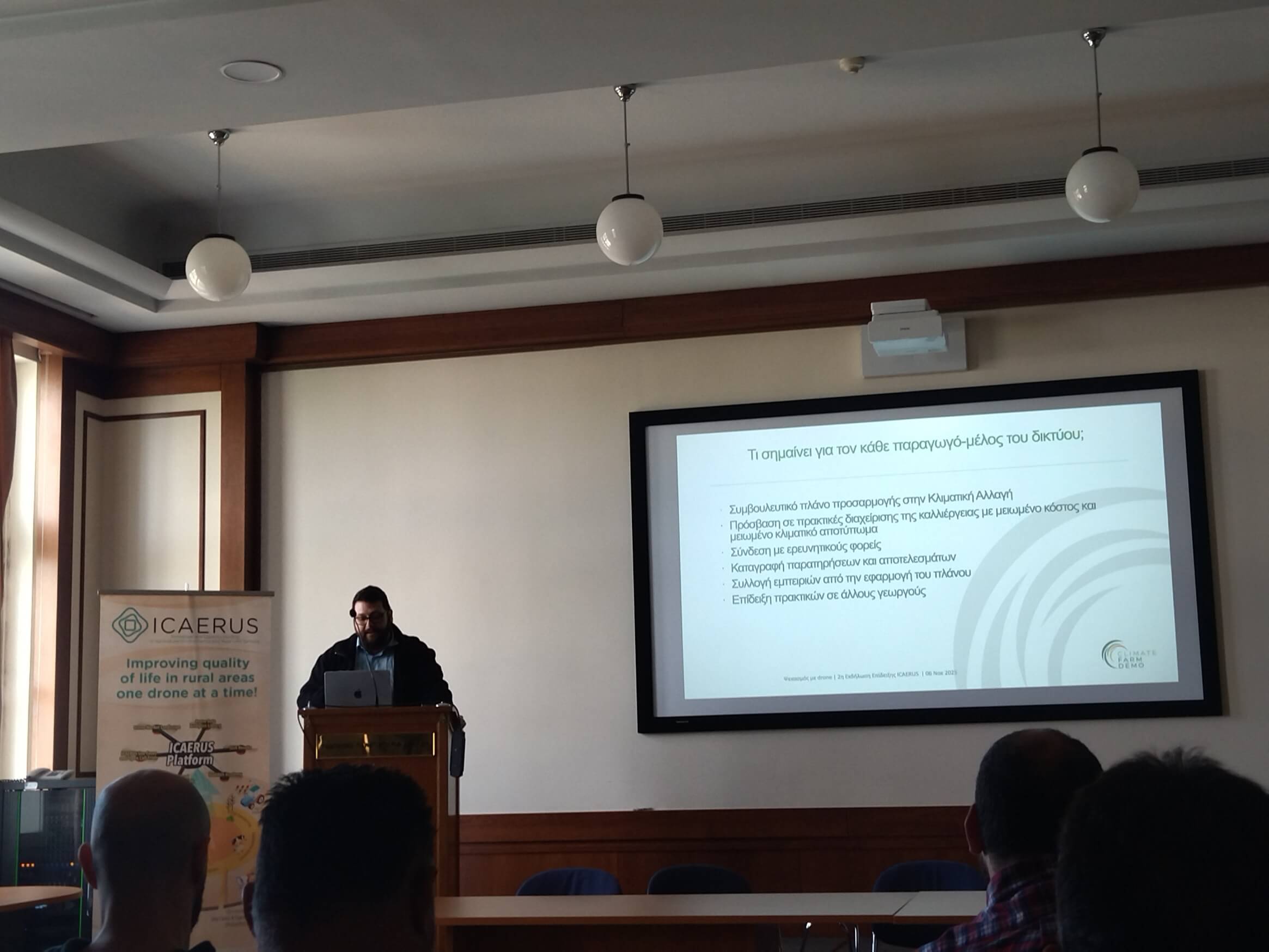 Presenter discussing a climate adaptation plan slide, in Greek