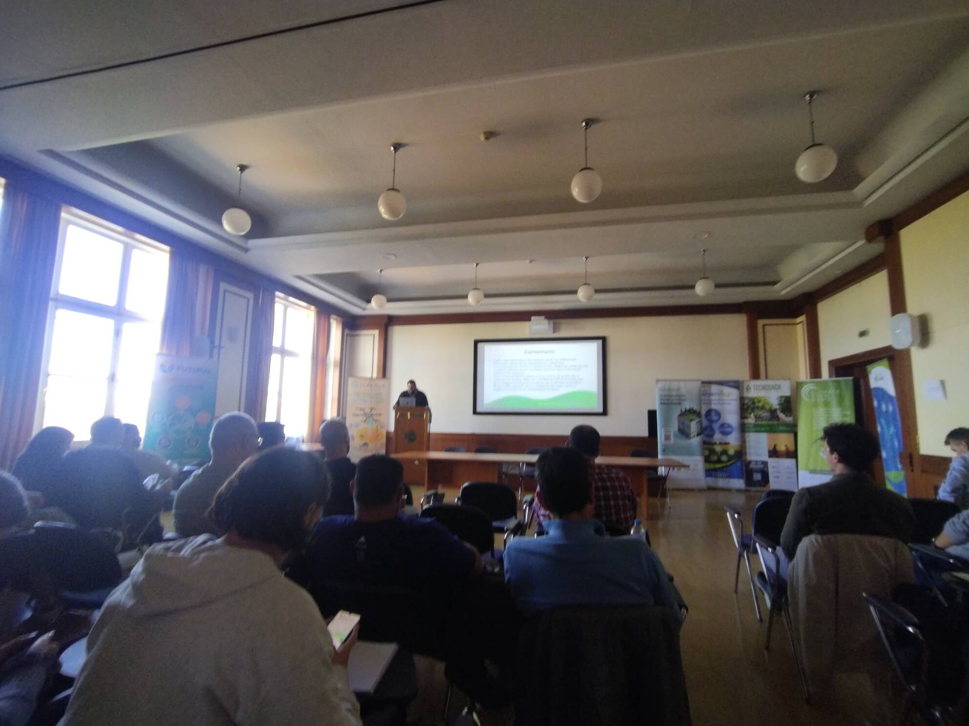 Wide view of the room and sponsor banners during the conclusions slide